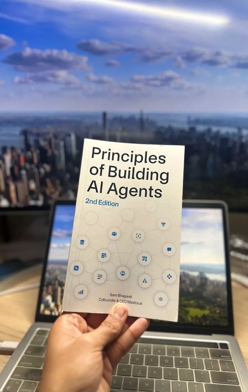 Principles of Building AI Agents — held at a desk